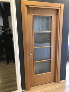 a wooden door with glass on the front and side panels, in a room that is painted blue