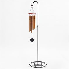 a wind chime is hanging from a pole on a white background with black diamond accents