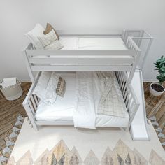 a white bunk bed sitting on top of a wooden floor next to a potted plant