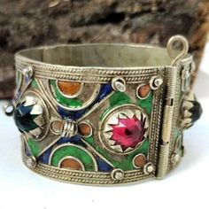 Vintage Moroccan Handmade Berber Silver Bracelet with Glass and enamel - Old Ethnic Jewelry, Handcrafted Berber Bracelet, Old cuff Bracelet A genuine masterpiece of art is this refined artisanal vintage Moroccan Berber bracelet. This piece of jewelry is made of silver and boasts a highly ornate design which demonstrates the deep-rooted tradition of Berber craftsmanship. It has dazzling glass stones and bright enamel work that bring color and stylishness to the band. Every bit of this bracelet is Bohemian Silver Bracelets With Meenakari, Traditional Jeweled Green Bracelets, Traditional Green Jeweled Bracelets, Artisan Cuff Bracelet As Festival Gift, Artisan Bangle As Festival Gift, Artisan Bangle For Festivals And Gifts, Artisan Bangle For Festivals As A Gift, Artisan Bangle As Gift For Festivals, Artisan Bangle As A Gift For Festivals