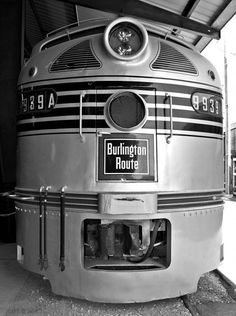 a black and white photo of a train parked in a station with the door open