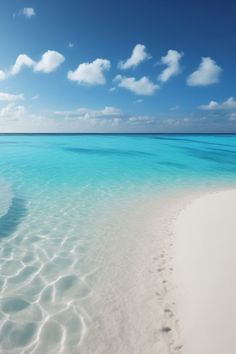 an empty beach with clear blue water and white sand