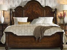 a large bed sitting next to two lamps on either side of the headboard and foot board