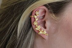 This magical ear cuff is perfect to embrace that whimsical fairy look. Wraps around your ear with a bouquet of tiny little flowers, leaves and pearls decorating it all along. *Choose between 14k gold, rose gold or silver plated brass. *Comes in a pretty gift wrap. For updates, new products, one-of-a-kind's, special offers and more-  like us on Facebook: https://www.facebook.com/avigailadamjewellery Follow me on Instagram: https://instagram.com/avigailadamjewelry/ Whimsical Gold Jewelry For Spring, Spring Whimsical Gold Jewelry, Whimsical Spring Gold Jewelry, Unique Cartilage Earrings For Wedding, Unique Wedding Cartilage Earrings, Bohemian Gold Ear Climbers As Gift, Elegant Spring Ear Cuff For Pierced Ears, Bohemian Ear Cuff For Weddings With Pierced Ears, Bohemian Single Ear Cuff For Wedding