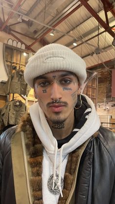 a man with tattoos and piercings on his face