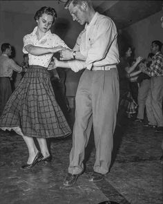 an old black and white photo of two people dancing