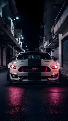 a white car parked on the street at night