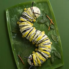 a caterpillar is sitting on a green plate