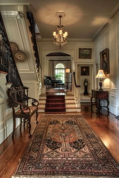 an ornate entry way with stairs and rugs