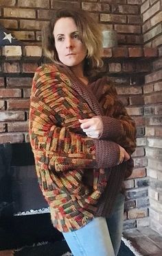 a woman standing in front of a brick fireplace with her arms crossed and looking at the camera