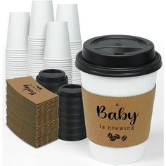 a coffee cup with its lid open next to several stacks of paper plates and napkins