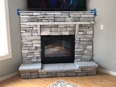 a television mounted on top of a stone fireplace