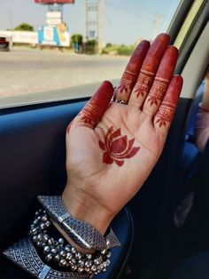 a woman's hand with hendix on it sitting in the passenger seat of a car