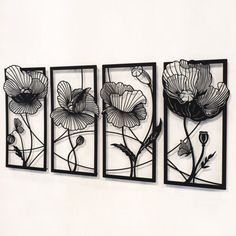 three metal wall art pieces with flowers on them