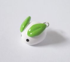 a green and white animal charm sitting on top of a table