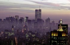 the city skyline is lit up at night with lights on and skyscrapers in the background