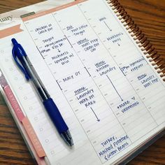 a spiral bound planner with a pen on top