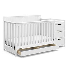 a white crib with two drawers and a drawer in the bottom right hand corner