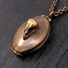 "This solid brass locket has been aged inside and out to give it a beautiful vintage patina. Measuring 1-1/8\" long by 13/16\" wide, the double locket opens up like an accordion providing ample room inside for four descent size images of those dear you, be they near or departed, pets included. The front of the locket is adorned with my tiny baby skull made of solid bronze. The back of the locket is adorned with an attractive fish scale design. The matching bronze soldered link chain is fitted wi Antique Gold Brass Necklace For Keepsake, Bronze Brass Jewelry Keepsake, Antique Metal Necklace For Keepsake, Antique Metal Keepsake Necklace, Antique Finish Brass Medallion Jewelry, Collectible Historical Jewelry With Antique Finish, Antique Gold Brass Pendant Locket Necklace, Unique Engraved Locket Necklace Collectible, Collectible Antique Finish Historical Jewelry