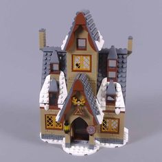 a toy house made out of legos with snow on the roof