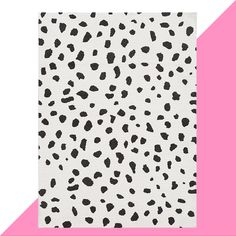 a pink and white background with black spots