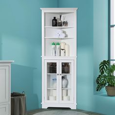 a bathroom with blue walls and a white cabinet in the corner next to a potted plant