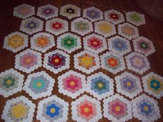 a quilted table topper on the floor with many different colors and shapes in it