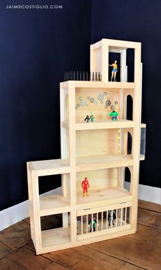 a doll house made out of wooden shelves with dolls on the top and bottom shelf