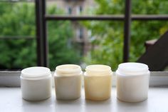 three jars sitting on top of a window sill