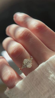 a person's hand with a diamond ring on it