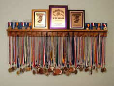 a wall mounted rack with medals and framed pictures