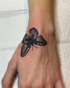 a woman's hand with a butterfly tattoo on it