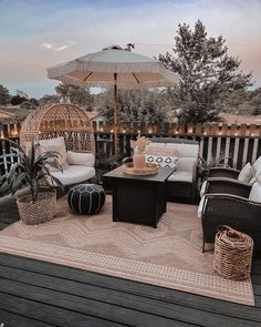 an outdoor patio area with wicker furniture and large umbrellas on top of it