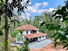 the house is surrounded by trees and greenery