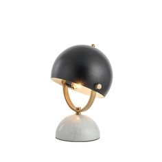 a black and white table lamp with a gold plated light on it's base