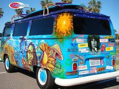 an old van painted with pictures and stickers is parked in a parking lot next to palm trees