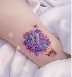 a woman's leg with purple flowers on it and a butterfly in the center