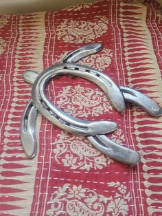 a pair of horseshoes laying on top of a red and white tablecloth covered bed