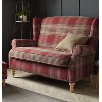 a red plaid couch sitting in a living room