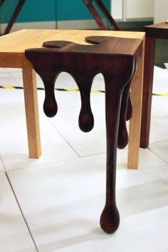 two wooden stools sitting next to each other on top of a white tile floor