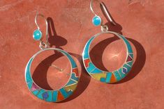 This beautiful Black Inca Calendar jewelry set is made by hand by the beautiful Quechua people of the Peruvian Andes. It is handmade in 950 silver, Lapiz Lazuli Stone and Turquoise Stone by a local family of jewelry artesians. Best quality artisan work PENDANT : Weight : 6.1 gr Diameter : 3.1 cm Height with the hook :4.5 cm EARRINGS: Weight: 11 gr Diameter : 3.1 cm Height with the hook : 5.3 cm Artistic Silver Jewelry For Festivals, Sterling Silver Artisan Jewelry With Inlay, Artisan Sterling Silver Jewelry With Artistic Design, Artisan Sterling Silver Jewelry With Inlay, Artisan Sterling Silver Inlay Jewelry, Bohemian Sterling Silver Jewelry For Festivals, Sterling Silver Jewelry For Festivals, Artisan Blue Jewelry For Festivals, Traditional Multicolor Nickel-free Jewelry