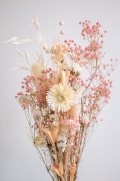 a vase filled with lots of white and pink flowers