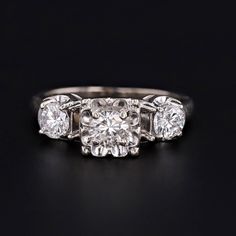 A lovely diamond engagement ring from the 1930s-1940s. This ring features a center stone of approximately 34 points (0.34 carat) and two side stones of approximately 26 points (0.26 carat) each. The center stone is H-I color color, SI2 clarity. The side stones are G-H color and SI2-I1 clarity. The total carat weight is 0.86 carat. A size 5.5, this ring is marked for 14k. It can be re-sized free of charge. The ring is in very good condition; however, there is a surface reaching natural inclusion Vintage Diamond Earrings, Vintage Diamond Engagement Ring, Diamond Engagement Rings Vintage, Jewelry Post, White Gold Diamond Rings, Wedding Rings Vintage, 14k White Gold Ring, 14k Gold Ring, Vintage Engagement