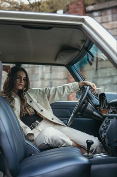 a woman sitting in the driver's seat of a car