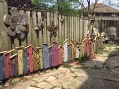 a row of colorful clothes hanging on a wooden fence