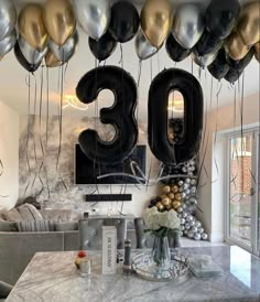 the table is decorated with balloons and streamers in the shape of numbers that spell out the number thirty