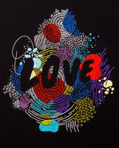 an embroidered t - shirt with the word love spelled out in multicolored letters