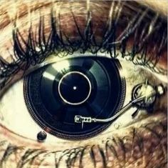 an eye with the reflection of a record player in it's irise,