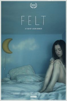 a woman sitting on top of a bed in front of a blue wall with the word felt