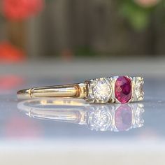 Details: Lovely Mid Century 14K yellow and white gold diamond and ruby ring, with two diamonds and a ruby. The ruby has a lovely rich pink color, and measures approx. 4.43mm. The two diamonds measure approx. 3.75mm. The diamonds and ruby are set in white gold, while the band is yellow gold. The interior of the ring has a sweet heart hallmark that says 14K. Please ask all necessary questions prior to placing an order. Measurements: The size is 6 3/4 US and can be sized for a fee. Condition: The o Classic Three Stone Ruby Ring With Diamonds, Heirloom Three Stone Ruby And Diamond Ring, Heirloom Three Stone Ruby Ring With Diamonds, Heirloom Three-stone Ruby And Diamond Ring, Heirloom Three-stone Ruby Ring With Diamonds, Classic Red Three Stone Diamond Ring, Red Three-stone Diamond Ring For Anniversary, Classic Pink Ruby Ring For Anniversary, Heirloom Ruby Ring With Vvs Clarity